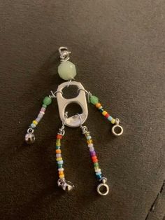 a keychain with beads and charms attached to it on a black surface next to a pair of scissors