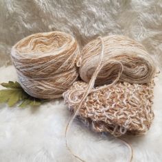 two skeins of yarn sitting on top of a white furnishing material