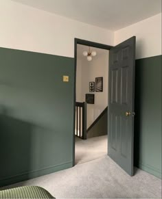 an open door leading to a bedroom with green walls and carpeted flooring on either side