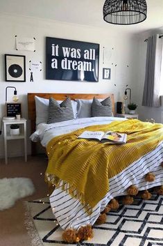 a bedroom with yellow and white bedding, black and white rugs and pictures on the wall