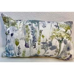 an image of a decorative pillow with flowers on the front and back cover in blue, green and white