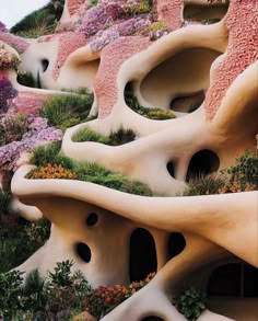 an artisticly designed building with flowers growing on the side