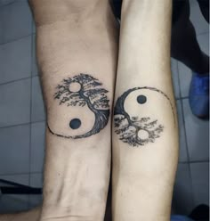 two people with tattoos on their arms holding each other's hands and one has a tree in the middle