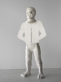 a sculpture of a man standing in front of a white wall with his hands on his hips