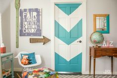 a blue and white painted door in a room with a striped rug on the floor