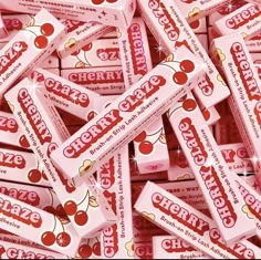 many pink candy bars are stacked on top of each other in a pile with cherries written on them