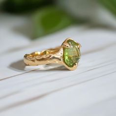 Bold but delicate, our stunning Peridot ring is uniquely handcrafted by wax and cast in Solid 14k Gold - the organic textured band adds a touch of rustic charm to this ethereal beauty. As the birthstone for August, this green crystal ring takes centre stage by creating a mesmerizing play of light. This one-of-a-kind engagement ring is not just a piece of jewelry; it's a poetic expression of individuality and everlasting commitment, making it the perfect embodiment of your unique love story.T H E Organic Gold Engagement Ring, Green Crystal Ring, Gold Peridot Ring, Nature Inspired Engagement Ring, Engagement Rings Affordable, Alternative Engagement Ring, Unique Nature, Textured Ring, Centre Stage