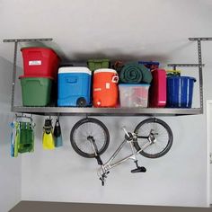 there is a bike that is parked on the shelf above the storage bins in this room