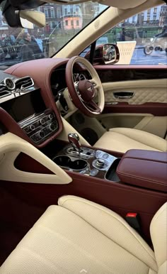 the interior of a car with beige leather and brown trims, including steering wheel