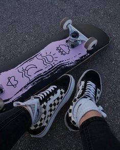 a person with their feet on a skateboard in the middle of the street, wearing black and white checkered shoes