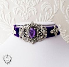 ♥Noir Romantique♥♥ Welcome to my store! This beautiful and elegant choker is made of purple fine velvet ribbon,embelished with beautiful ornate silver connectors harmonically combined to give an elegant and dramatic result. Purple gem 13x18mm is nestled within a silver setting .It fastens with silver chain and clasp.All components are silver plated made in America always of highest quality. ♥♥ If you need a specific length please let us know with a note. ♥ It will be sent to you in a beautiful g Weird Outfits, Victorian Gothic Jewelry, Purple Choker, Gothic Choker, Elegant Choker, Fairy Crown, Gothic Chokers, Purple Gems, Neck Accessories