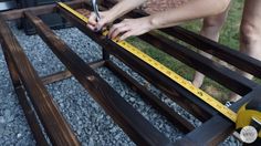 a woman measuring the width of a bench with a pair of scissors and tape measure