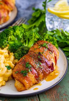 a plate with meat, macaroni and cheese and broccoli on it