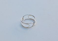 a silver ring sitting on top of a white surface