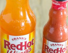 two bottles of hot sauce sitting on top of a table