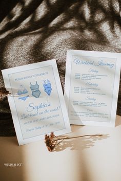 two wedding cards sitting on top of a table