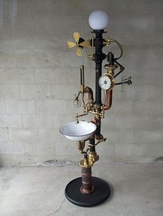 an old fashioned lamp with two sinks on it's base and pipes attached to the side