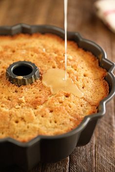 a cake pan filled with batter being drizzled on top of the cake