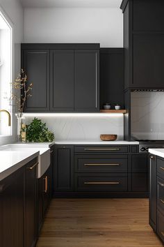 a kitchen with black cabinets and white counter tops