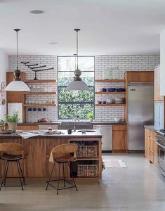 an open kitchen with wooden cabinets and stools