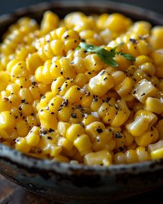 a bowl filled with corn on top of a wooden table