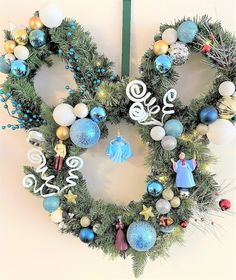 a christmas wreath hanging on the wall with ornaments around it and an ornament