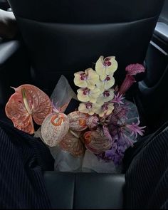 flowers are placed in the center console of a car's interior, along with other decorative items