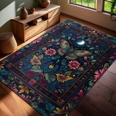 a blue rug with flowers and butterflies on it in front of a window, next to a dresser