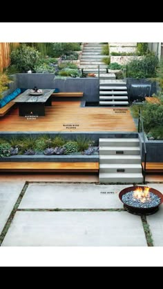 an outdoor fire pit surrounded by steps and plants