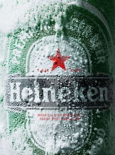 a close up of a bottle of beer covered in ice and water with a red star on the top