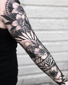 a woman's arm with black and white flowers on it