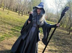 a woman dressed up as a wizard holding a staff