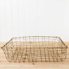 a wire basket sitting on top of a wooden table