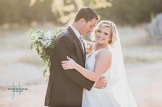 a bride and groom pose for a wedding photo in front of an elephant at sunset