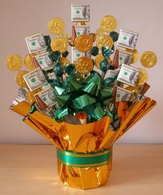 a gold vase filled with lots of money and wrapped in green ribbon on top of a wooden table