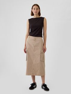 Soft, stretch utility midi skirt.  Button closure, zip fly.  Front slant pockets, back welt pockets.  Side cargo pockets.  Slit at back hem.  * Fit: Classic.  A pencil silhouette that's slim at the waist & easy through the hip with a tapered opening.  Hits below the knee.  Models wearing Gap Long Khaki Skirt Outfit, Cargo Midi Skirt Outfit, Khaki Skirt Outfits, Long Khaki Skirt, Midi Cargo Skirt, Utility Fashion, Cargo Skirt Outfit, Queer Style, Cargo Midi Skirt