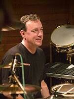 a man sitting in front of a drum set