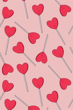 red lollipops with hearts on them are arranged in rows against a pink background