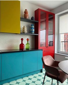 a kitchen with red, yellow and blue cabinets