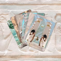 four cards with an image of a woman in white dress and gold jewelry on them