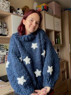 a woman wearing a blue sweater with white stars on it