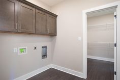 an empty closet with wooden cabinets and white walls