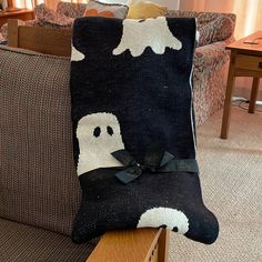 a black and white pillow sitting on top of a wooden table next to a couch