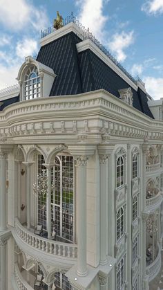 a large white building with lots of windows and balconies on top of it