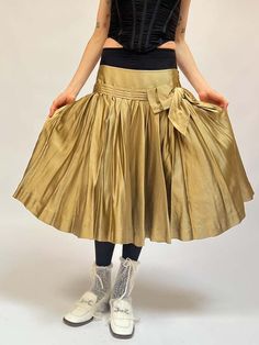 Vintage y 2k era dkny gold silk knee length skirt. flat waist with a line of pleating with soft pleating around the skirt. has a dramatic oversized matching gold bow at the left hip. unlined. super lightweight and in great vintage shape.    measurements (in inches)    30 in waist    46 in hips    25 in length    materials    silk Vintage Dkny, Bow Skirt, Y2k Era, Silk Bow, Black Tank Dress, Black Aviators, Neon Purple, Gold Silk, Boyfriend Tee