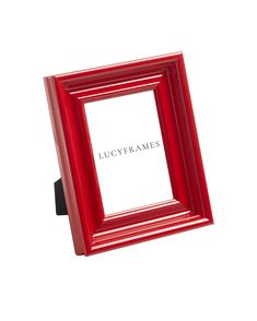 a red frame sitting on top of a white wall next to a black object with the word lucgyframes written in it