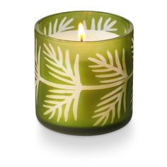 a green candle with white leaves on it