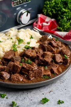 a plate full of meat and mashed potatoes next to an instant pot roaster