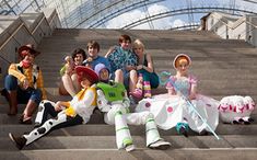 several people dressed up as toy story characters sitting on steps with stuffed animals in front of them