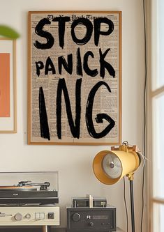 an old record player sitting on top of a wooden table next to a poster with the words stop panicing